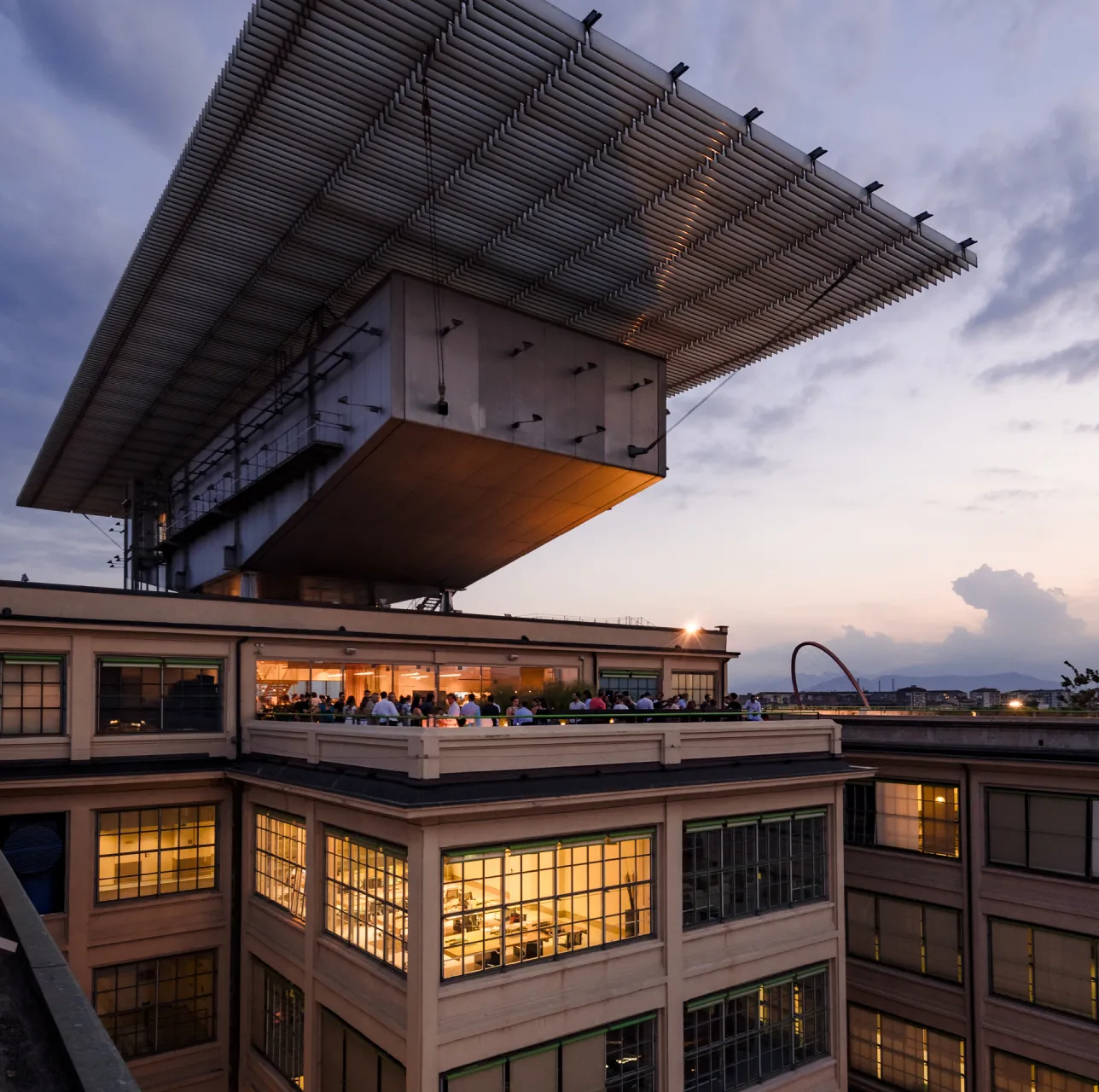lingotto-LA-PISTA Padiglione panoramico Renzo Piano sul tetto del Lingotto Torino al tramonto, con persone sulla terrazza e luci accese