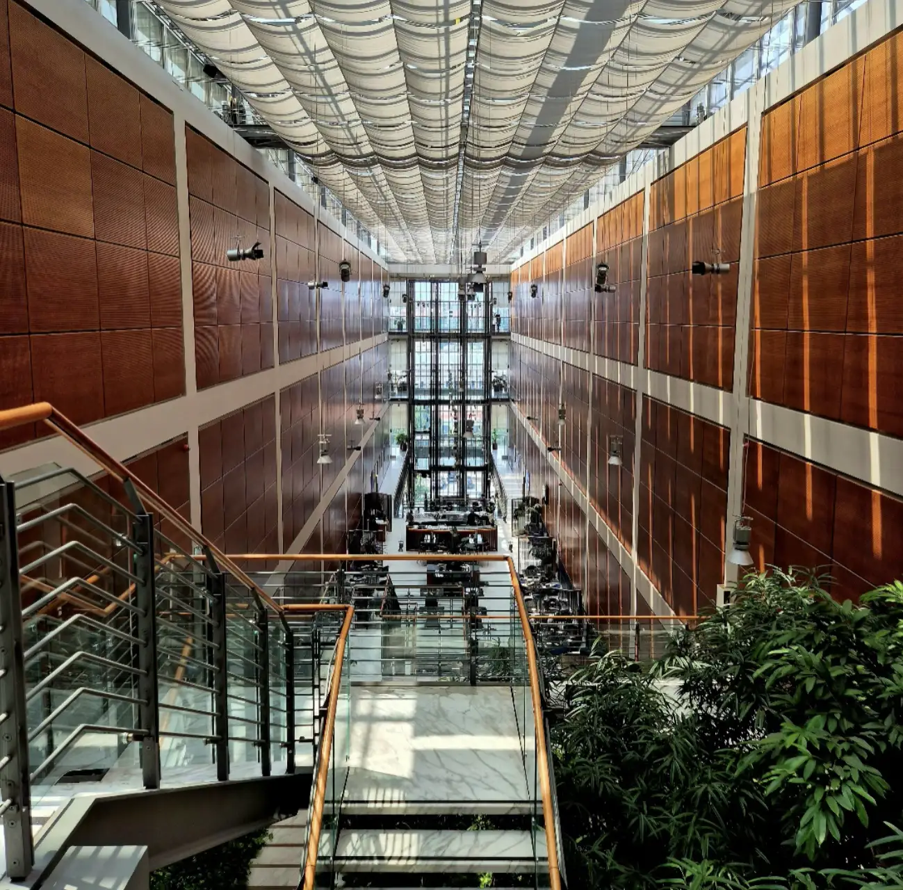 centro-commerciale-lingotto-comprensorio-doubletree-by-hilton Interno moderno della biblioteca centrale “Norberto Bobbio” Politecnico di Torino al Lingotto, con vetrate, pareti in legno e tetto ondulato.