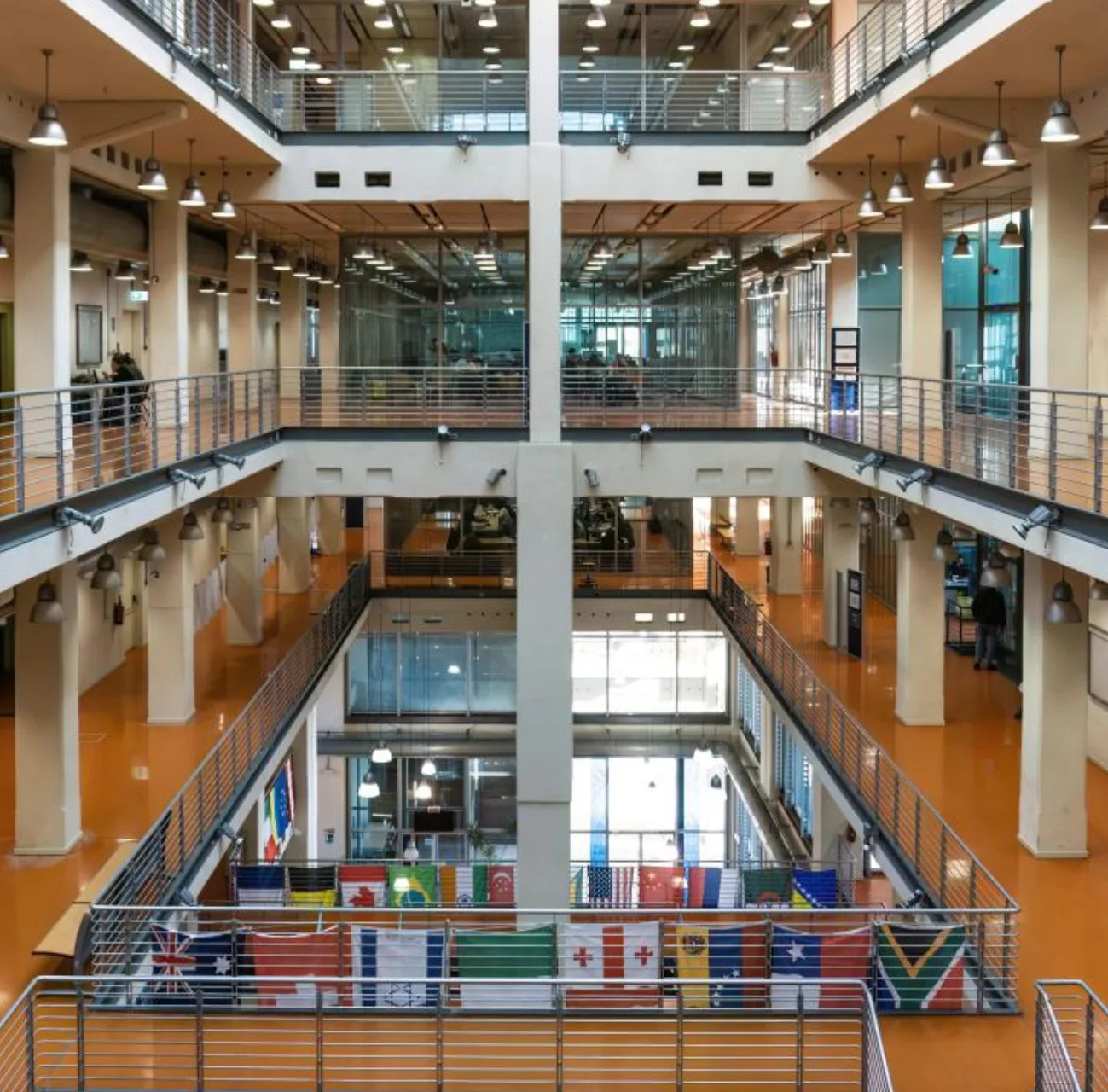 centro-commerciale-lingotto-comprensorio-politecnico Interno moderno e luminoso del centro congressi Lingotto Torino, con bandiere internazionali esposte e corridoi su più livelli.