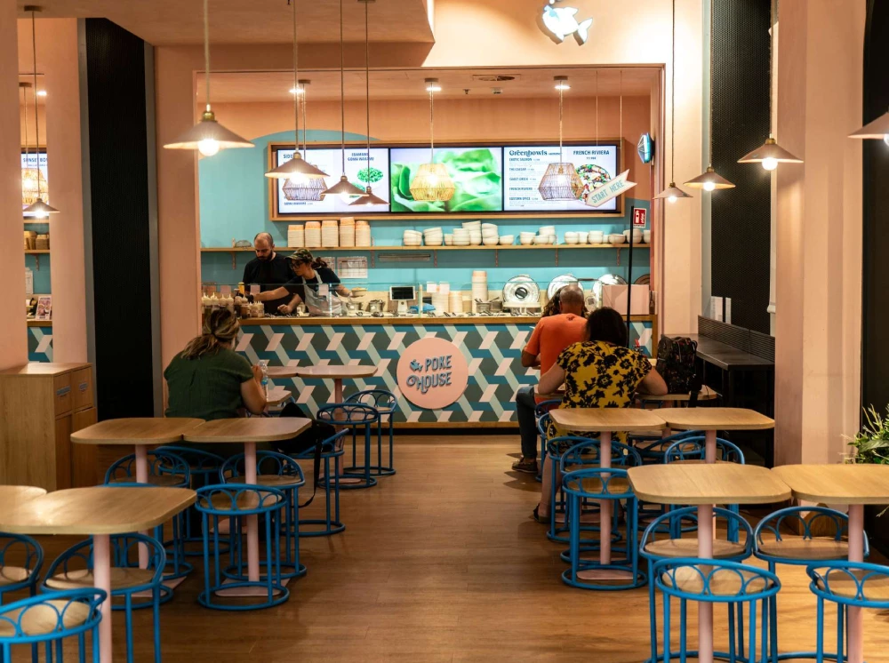 Interno ristorante Poke House Lingotto Torino colori pastello