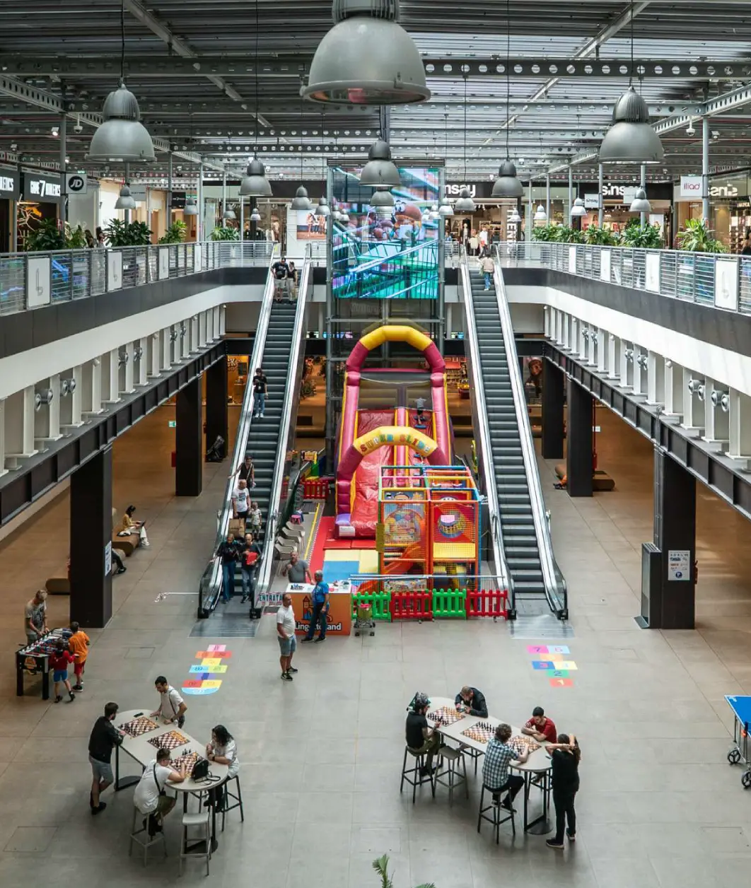 Interno centro commerciale con area giochi e scacchi