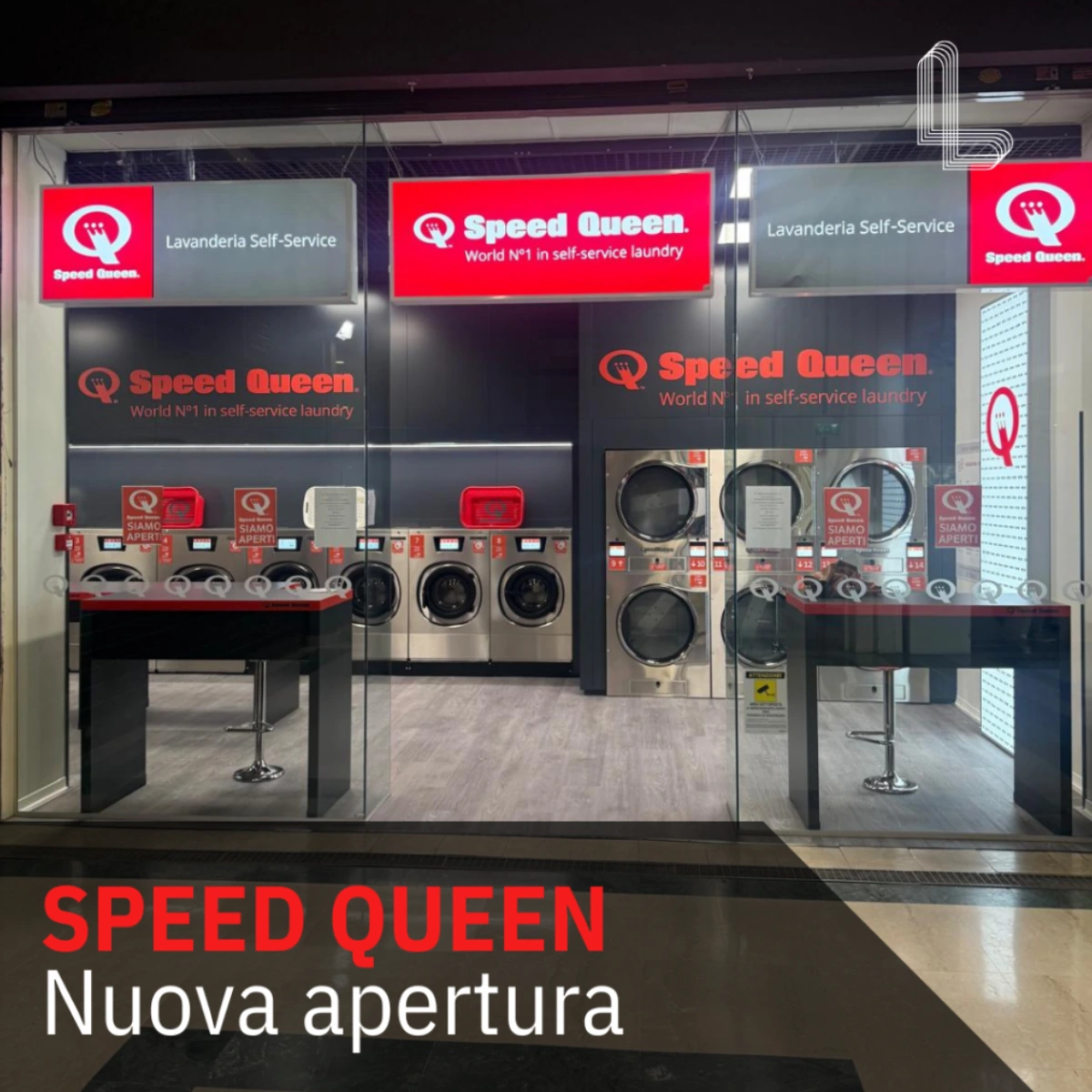Vista dell’ingresso della lavanderia self-service Speed Queen al Lingotto Torino, con lavatrici e arredamento moderno.